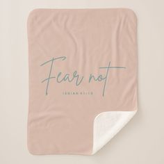 a pink blanket with the word fear not printed on it and a white towel underneath