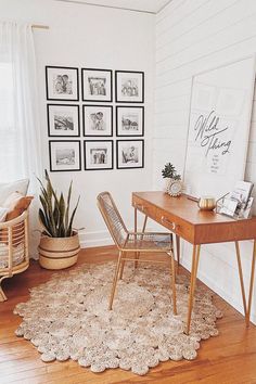 a living room with pictures on the wall and a desk in front of it,