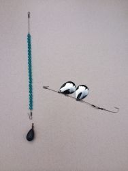 two birds sitting on top of a blue beaded necklace next to a hook with beads