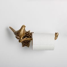 a toilet paper holder with two birds on it and a roll of toilet paper in the middle