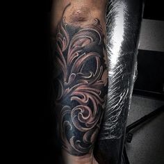 a man's arm with an intricate tattoo design on the left side of his leg