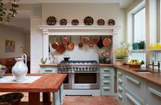 a kitchen with pots and pans hanging on the wall above the stove, counter top