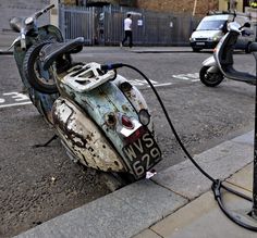 an old rusty motorbike is hooked up to a gas pump