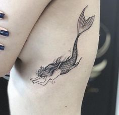 a woman with a mermaid tattoo on her stomach