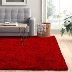 a living room with a couch, coffee table and red rug