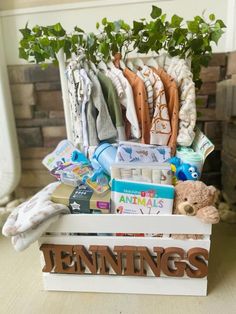 a wooden crate filled with lots of baby items next to a potted plant on top of a table