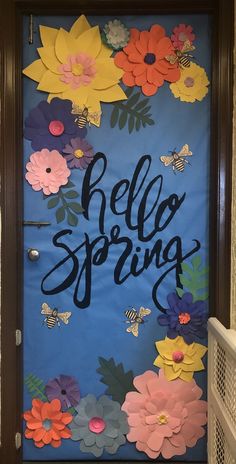 a door decorated with paper flowers and the words hello spring