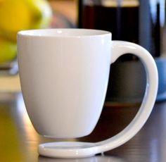 a white coffee cup sitting on top of a table