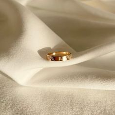 a gold ring sitting on top of a white cloth