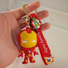 a hand holding an iron man keychain that says, i love my hero