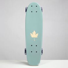 a skateboard with a maple leaf painted on the front and back wheels, against a gray background