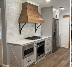 a stove top oven sitting inside of a kitchen next to a wall mounted range hood