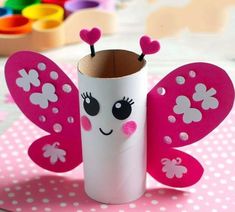 a toilet paper roll with a pink butterfly on it's side and hearts painted on its wings