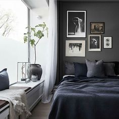 a bedroom with black walls and pictures on the wall