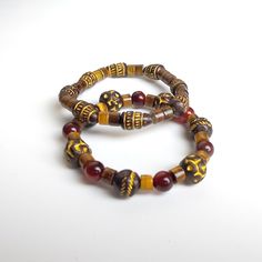 Elevate your style with this striking set of two handmade bracelets, crafted with a blend of tribal wood beads, vibrant red agate, and mesmerizing tiger's eye. Sized at 7 inches, these bracelets offer a perfect balance of natural earth tones and rich, bold colors, making them an ideal accessory for any occasion. Design Features: Tribal Wood Beads: Add a rustic and earthy touch with these unique beads that bring a sense of grounded authenticity. Red Agate: Known for its protective and calming properties, red agate beads infuse the bracelets with vibrant energy. Tiger's Eye: A stone of confidence and strength, tiger's eye adds a dynamic contrast with its captivating, shimmering hues. Wear them together for a stacked look, or separately for a more subtle statement. Whether you're dressing up Traditional Brown Beaded Bracelets With Natural Stones, Traditional Wooden Beads Bracelets For Festival, Traditional Adjustable Beaded Bracelets With Natural Stones, Traditional Brown Beaded Bracelet With Natural Stones, Traditional Adjustable Beaded Bracelets With Wooden Beads, Traditional Wooden Beads Bracelet For Festival, Traditional Adjustable Bracelet With Wooden Beads, Traditional Adjustable Wooden Bead Bracelet, Traditional Adjustable Wooden Beads Bracelet