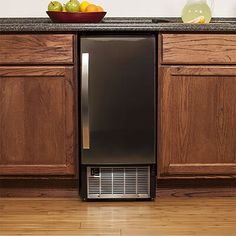 a dishwasher sitting on top of a kitchen counter next to a bowl of fruit