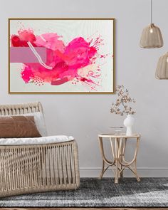 a living room with a wicker chair and pink painting on the wall above it