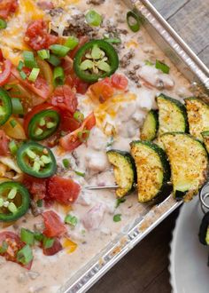 an assortment of vegetables being served on a platter with dip and sauce for dipping