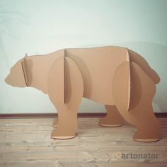 an animal made out of cardboard sitting on the floor