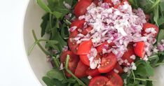 a salad with onions, tomatoes and spinach