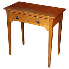 a small wooden table with two drawers on one side and an open drawer on the other