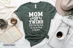 a t - shirt with the words mom off twins on it next to an open book