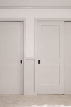 three white doors in an empty room with carpet