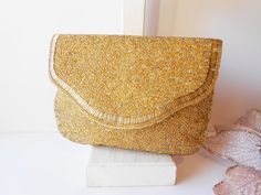 "Dazzling vintage Magid gold evening bag. This glamorous bag is a gold beaded bag. It has a mix of gold micro beads and gold iridescent beads. It really sparkles. The interior of the bag is gold satin and it contains one pocket. This is a beaded clutch bag and it has a snap closure. A very glamorous gold handbag. MATERIAL: Beading, satin CONDITION: It is in good condition SIZE: It measures 8\" wide and 6\" high COLOR: Gold" Gold Sequined Bags As Gifts, Gold Sequined Bags For Gifts, Gold Sequin Bags For Gifts, Elegant Gold Sequined Shoulder Bag, Gold Rectangular Clutch For Festive Occasions, Gold Sequined Shoulder Bag For Evening, Festive Gold Rectangular Clutch, Gold Beaded Pouch Shoulder Bag, Gold Beaded Pouch Bag