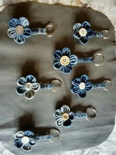 blue and white flowers are attached to the back of a leather purse with metal rings