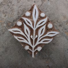 a white and brown decorative object sitting on top of a cement slab