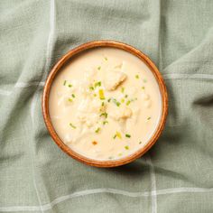 a wooden bowl filled with food on top of a green cloth