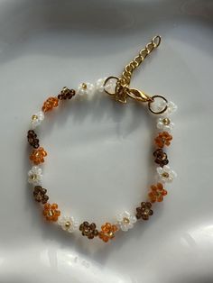 a beaded bracelet on a white plate with gold clasps and beads in the shape of flowers