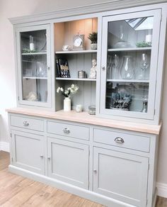 a white china cabinet with glass doors and drawers