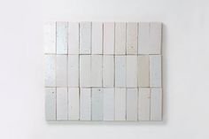 a square white tile wall hanging on the wall