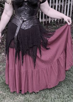 a woman in a black corset and red skirt is posing for the camera