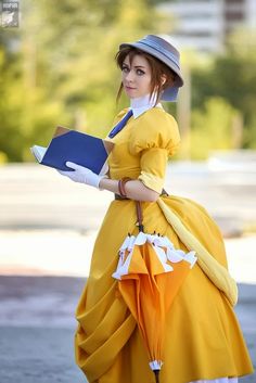 a woman in a yellow dress is holding a book