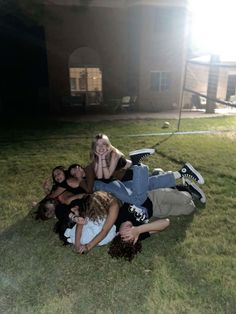 a group of people laying in the grass together