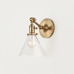 an antique brass wall light with clear glass shade