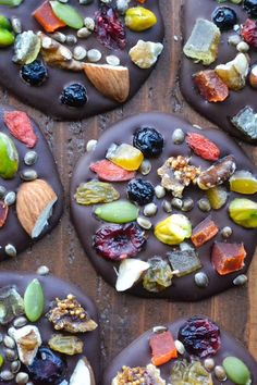 there are many pieces of chocolate with nuts and dried fruits on it, including raisins