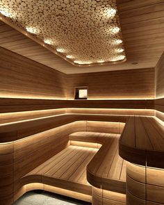 a room with wooden benches and lights on the ceiling is lit by recessed lighting