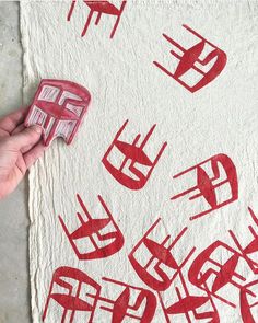 someone is using red ink to make a piece of artwork on the ground with their hand