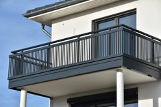 a white house with black balconies on the balcony