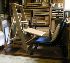 a chair sitting on top of a hard wood floor next to a book shelf filled with books