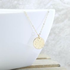 Give her the MOON! The peacefulness of the moon is captured in this hammered gold disc necklace, and it is the perfect addition to your collection. And the perfect gift for the woman who has everything. She will NEVER take it off!Gorgeous rich 1/2" (13mm) 14k gold fill disc is lightly hammered to create a unique textured look... every single one will be slightly different. This hangs from a 1.6mm gold filled cable chain to complete the look.  It can be worn alone, or layered with other pieces so Minimalist Hammered Coin Necklace As Gift, Minimalist Hammered Coin Necklace Gift, Circle Moon Charm Necklace For Gift, Hammered Coin Necklace As Gift, Hammered Round Disc Coin Necklace As Gift, Hammered Coin Necklace Gift, Dainty Hammered Coin Necklace As Gift, Moon Phase Coin Necklace As Gift, Gold Moon Phase Coin Necklace As Gift