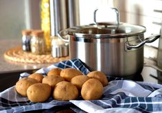 some food is sitting on a blue and white checkered towel near a large pot