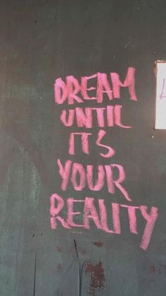 graffiti on the side of a building reads, dream until it's your reality