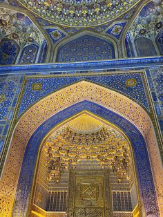 the inside of an ornate building with blue and gold tiles on it's walls