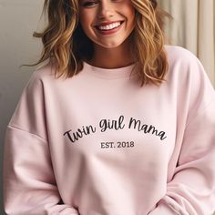 Celebrate the joy of motherhood with this cozy "Twin Girl Mama" crewneck sweatshirt, featuring a customizable date to make it truly unique. Whether you're a proud twin mama yourself or looking for the perfect gift, this stylish and comfortable sweatshirt is ideal for twin moms who embrace their role with love and pride. Great for baby showers, Mother's Day, birthdays, or simply as a thoughtful gesture to show appreciation, this sweatshirt will be a favorite in any twin mama's wardrobe. Product Details:   - Unisex heavy blend crewneck made from a soft cotton-poly blend for all-day comfort.   - Ethically made using 100% US-grown cotton and OEKO-TEX-certified dyes with low environmental impact.   - Ribbed collar retains shape after washing, with no itchy side seams for added comfort.   - Mach Pink Long Sleeve Sweatshirt With Name Print, Mother's Day Family Matching Crew Neck Sweatshirt, Family Matching Crew Neck Sweatshirt For Mother's Day, Mother's Day Crew Neck Sweatshirt With Lettering, Mother's Day Sweatshirt With Name Print And Crew Neck, Family Matching Long Sleeve Tops For Gender Reveal, Mother's Day Lettering Crew Neck Sweatshirt, Pink Crew Neck Sweatshirt For Mother's Day, Long Sleeve Tops For Mother's Day Loungewear