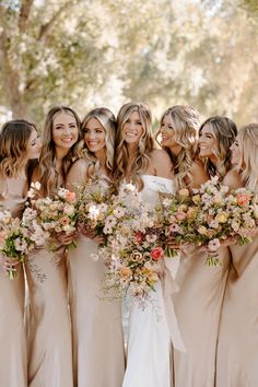 a group of women standing next to each other holding bouquets