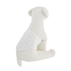 a white stuffed animal sitting on top of a pillow in the shape of a dog